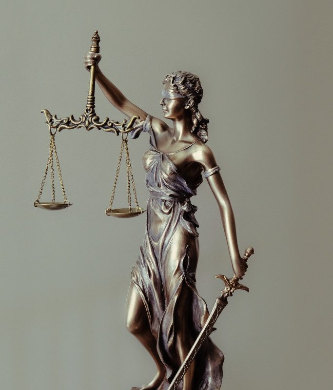 statue of a woman holding a weighing scale and a sword on her other hand