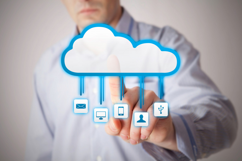 A man tapping on cloud computing related icons