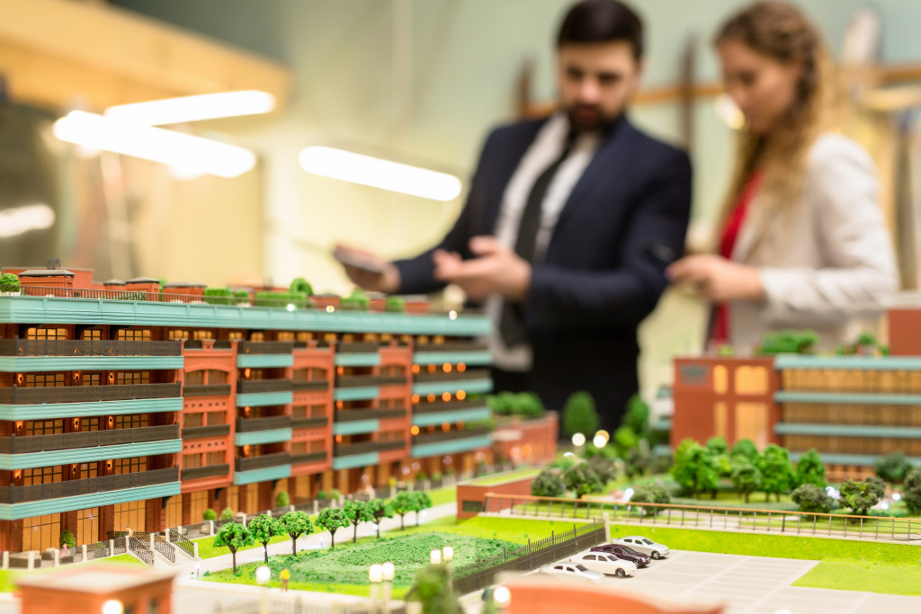 businessman looking at a mini model of a commercial building